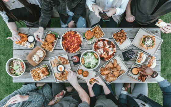 a group of people sitting around a table with food